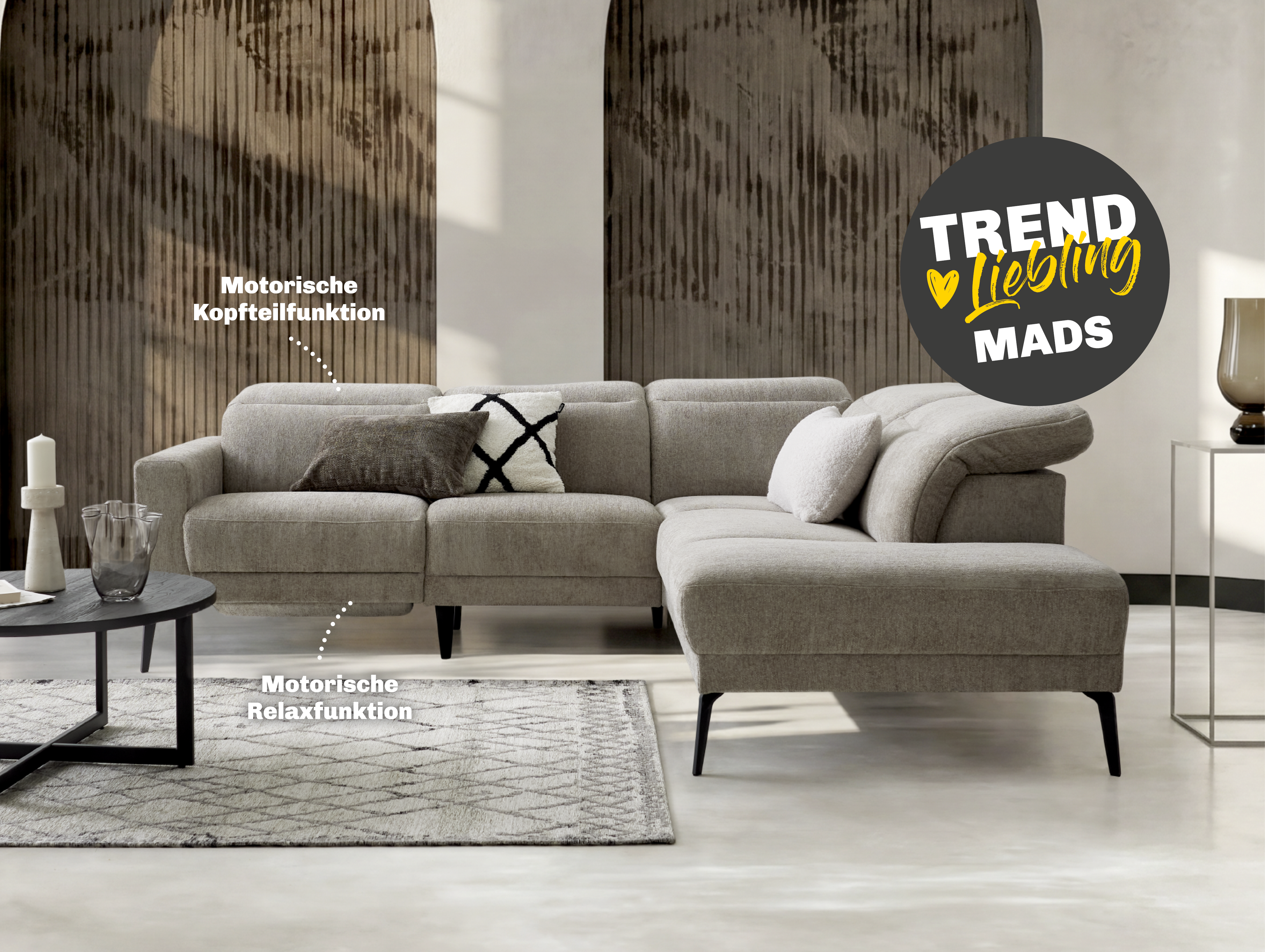 Ecksofa Mads in einem stilvollen Wohnzimmer mit motorischer Kopfteil- und Relaxfunktion.